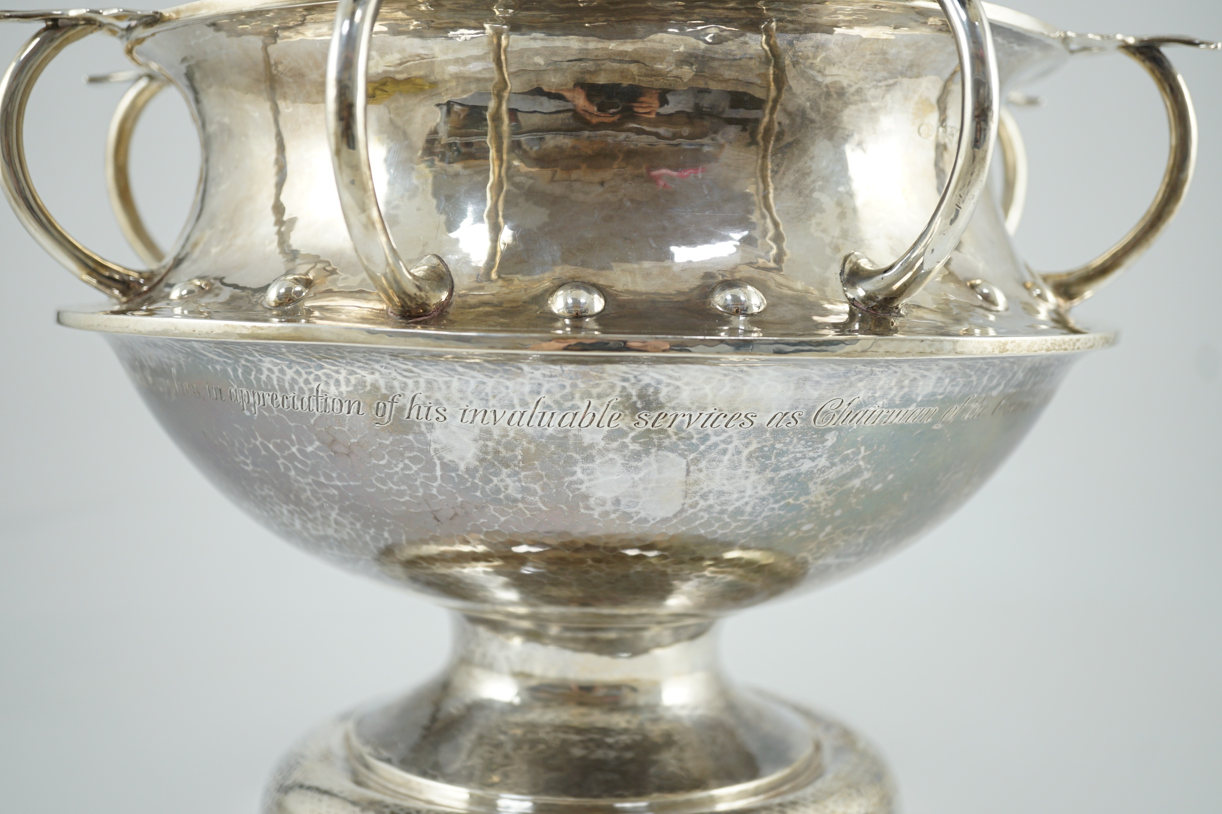 A George V Arts & Crafts planished silver octuple handled pedestal punch bowl, by Albert Edward Jones